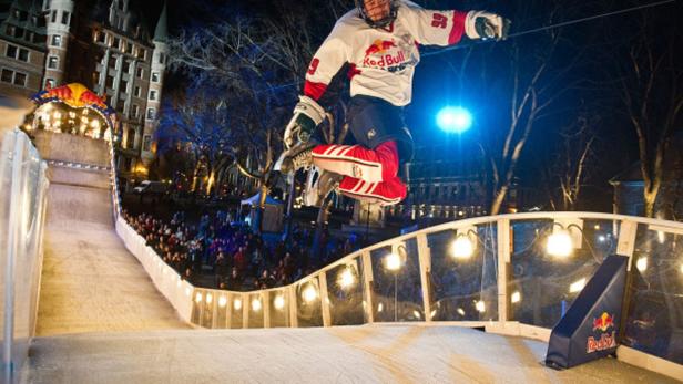 Ein Eiskunstläufer springt während eines Red Bull Crashed Ice Events in der Luft.