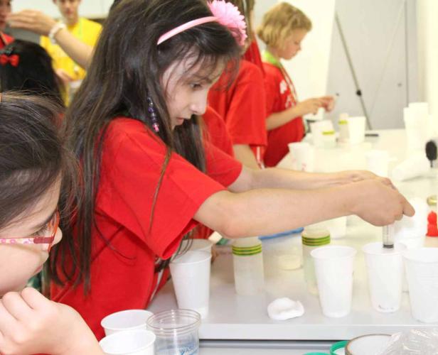 Mädchen experimentieren im Labor mit Pipetten und Bechern.