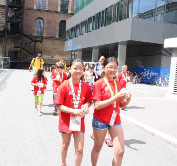 Eine Gruppe Kinder in roten T-Shirts geht eine Straße entlang.