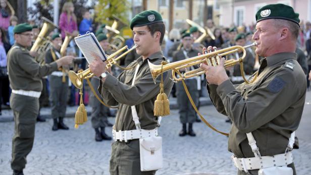 Eine Militärkapelle spielt Trompete bei einer Veranstaltung im Freien.