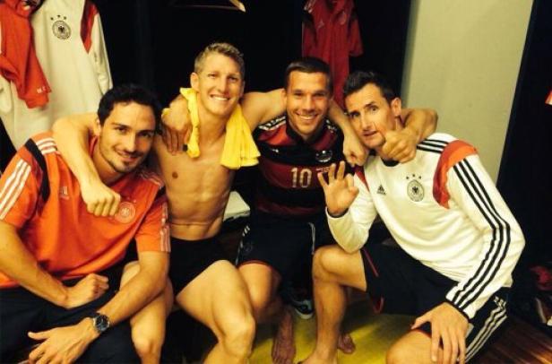 Vier deutsche Fußballspieler posieren im Mannschaftsbus für ein Foto.