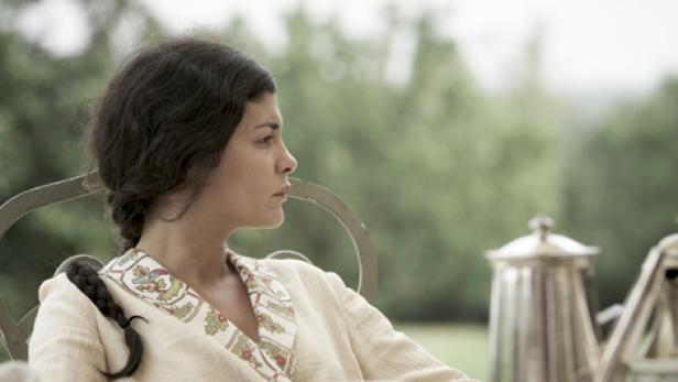 Audrey Tautou sitzt in einem Sessel und blickt nachdenklich zur Seite.