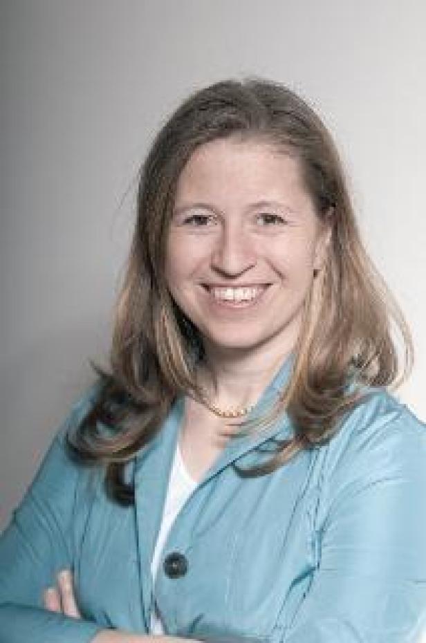 Caroline Krall, Dialogium/Dialogium Eine lächelnde Frau mit blonden Haaren und blauem Blazer vor einem hellen Hintergrund.