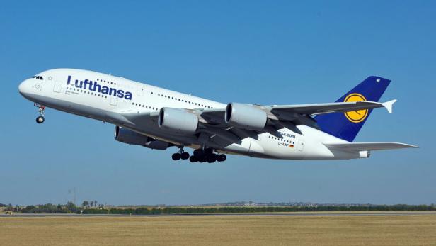 Ein Lufthansa Airbus A380 startet vor blauem Himmel.
