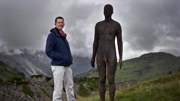 "Horizon Field" nannte Gormley auch die Landschaftsinstallation in Vorarlberg. Ein Mann steht neben einer nackten Skulptur vor einer Bergkulisse.
