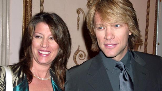 Jon Bon Jovi posiert mit einer Frau auf einer Veranstaltung.