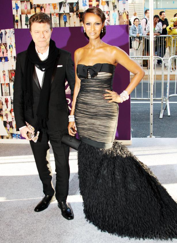 David Bowie und Iman posieren auf einem roten Teppich.