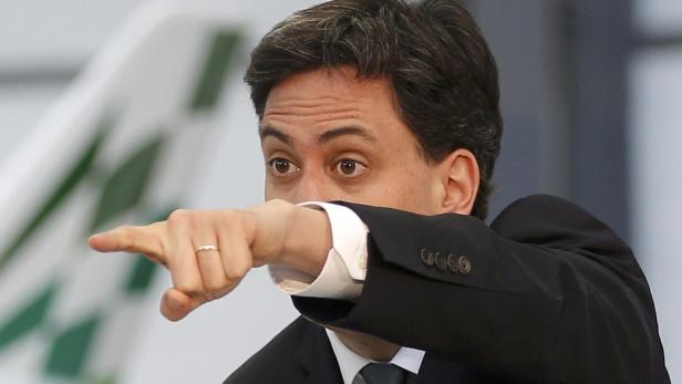 Ein Mann im Anzug deutet mit dem Finger nach links.