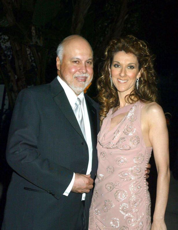 Céline Dion posiert mit einem Mann in einem dunklen Anzug.