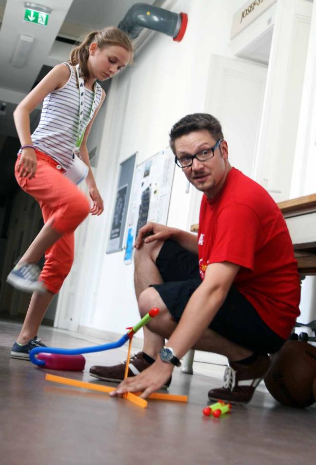 Ein Mann und ein Mädchen spielen mit einem Spielzeugraketenwerfer.