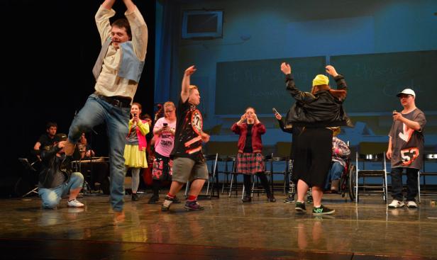 Eine Gruppe von Menschen mit Behinderung tritt auf einer Bühne auf.