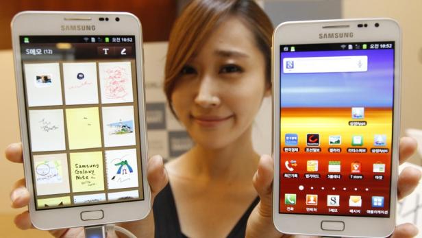 Eine Frau präsentiert zwei Samsung Galaxy Note 8 Smartphones.