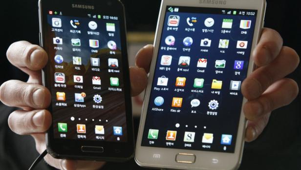Eine Person hält zwei Samsung-Smartphones mit koreanischen App-Symbolen in der Hand.