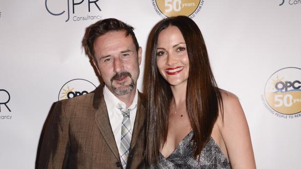 David Arquette posiert mit einer Frau auf einer Veranstaltung.