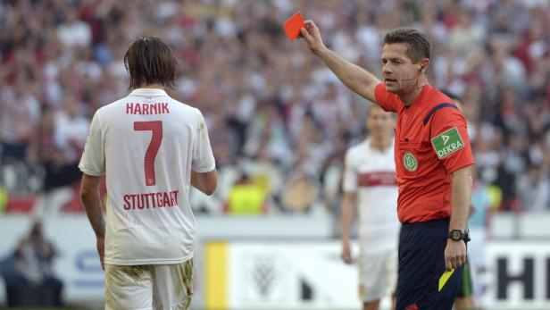 Ein Schiedsrichter zeigt einem Spieler von Stuttgart die Rote Karte.