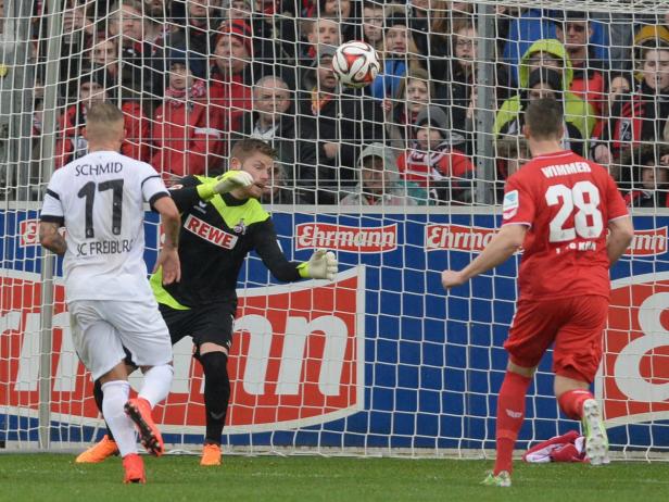 Ein Fußballspiel: Der Torwart versucht, einen Ball abzuwehren.