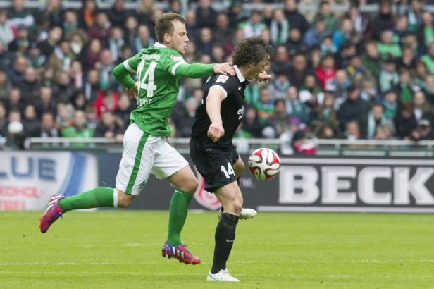 Zwei Fußballspieler kämpfen um den Ball auf dem Spielfeld.