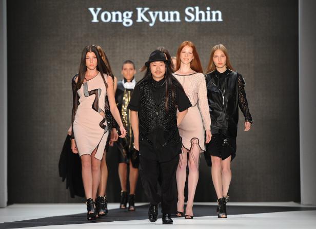 Yong Kyun Shin läuft mit Models über den Laufsteg.