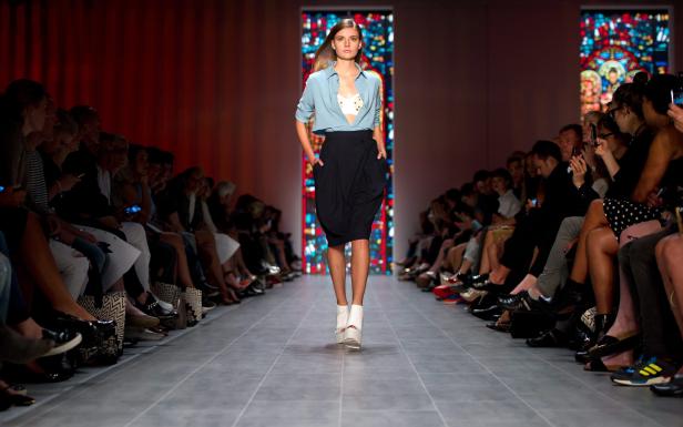 Eine Frau läuft auf einem Laufsteg während einer Modenschau.