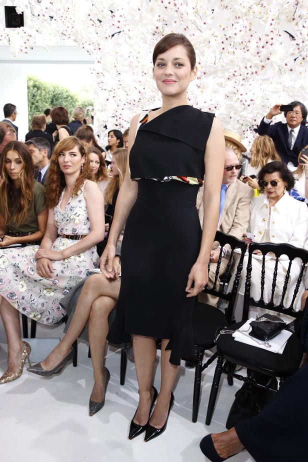 Marion Cotillard bei einer Modenschau in einem schwarzen Kleid.