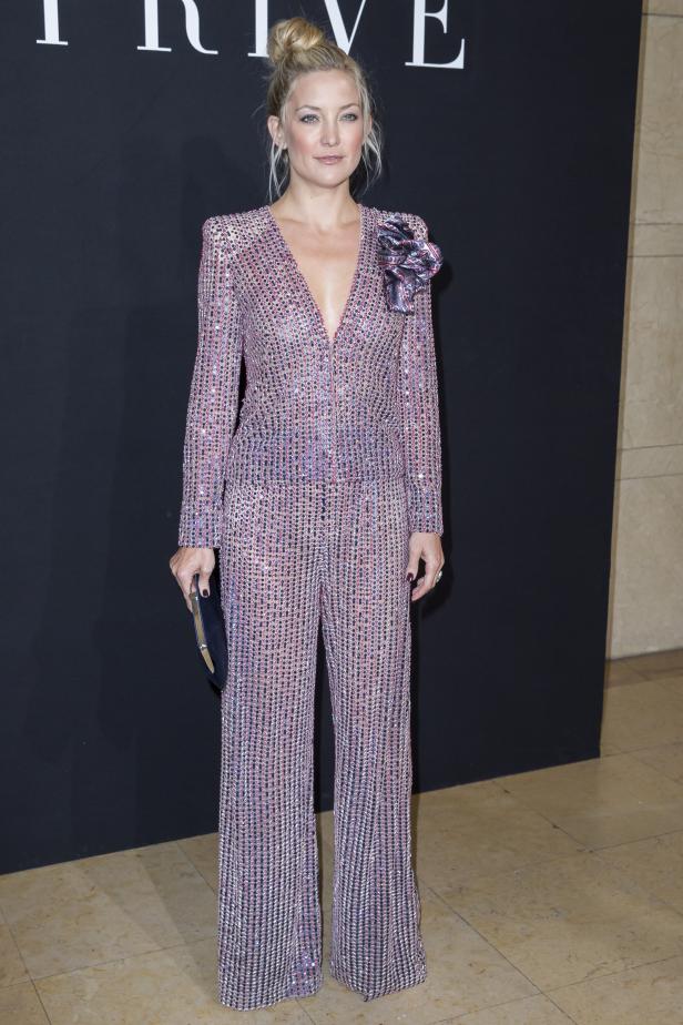 Kate Hudson in einem glitzernden Overall mit Blumenapplikation.