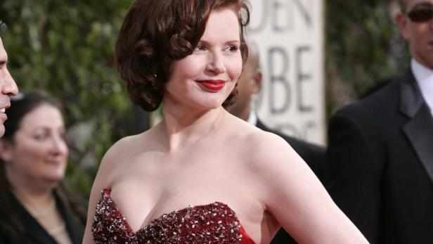 Geena Davis trägt ein rotes, trägerloses Kleid auf dem roten Teppich.