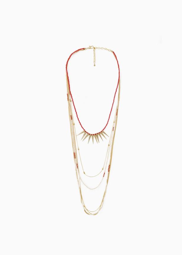 Eine mehrlagige Halskette mit roten Perlen und goldenen Anhängern auf weißem Grund.