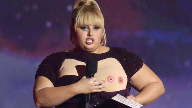 Rebel Wilson hält eine Rede in einem T-Shirt mit aufgedruckten Brüsten.