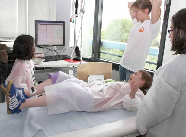 Ein junges Mädchen liegt während einer medizinischen Untersuchung auf einer Liege.