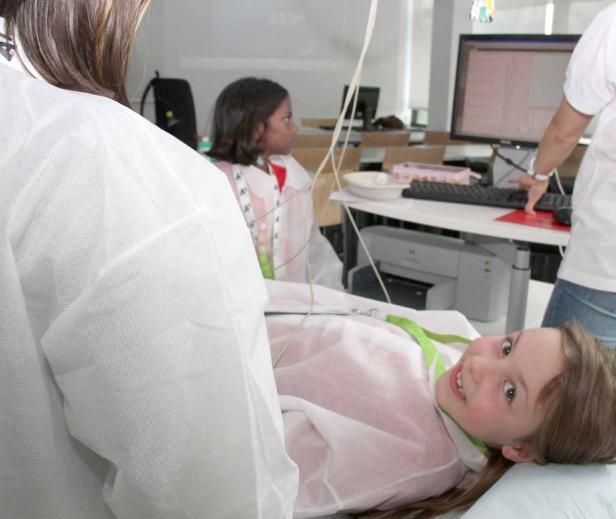 Ein Mädchen liegt für eine medizinische Untersuchung auf einer Liege.