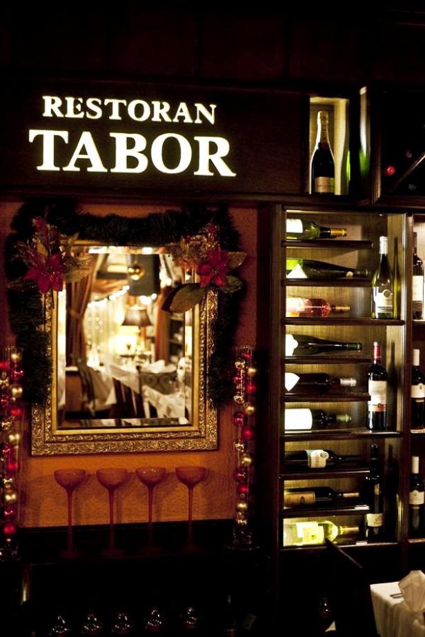 Innenansicht des Restaurants Tabor mit Weinregal und Spiegel.