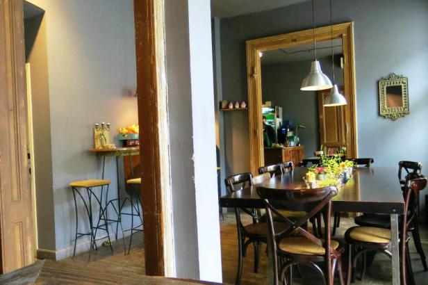 Ein langer Holztisch mit Stühlen in einem Restaurant oder Café.