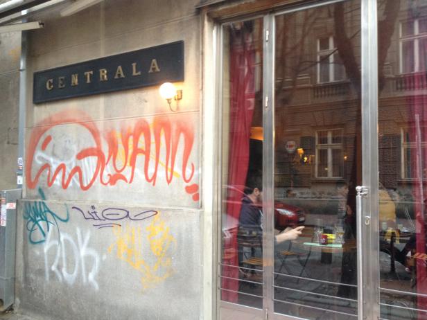 Das Café Centrala mit Graffiti an der Fassade und Gästen im Inneren.