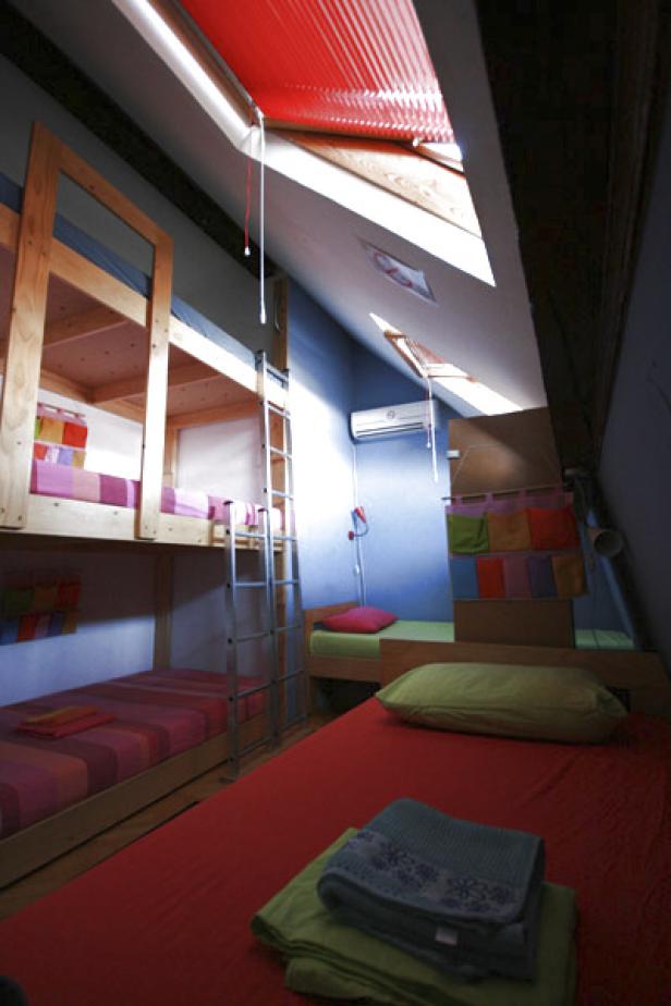 Ein Zimmer mit mehreren Betten, darunter ein Etagenbett, in einem Dachgeschoss.