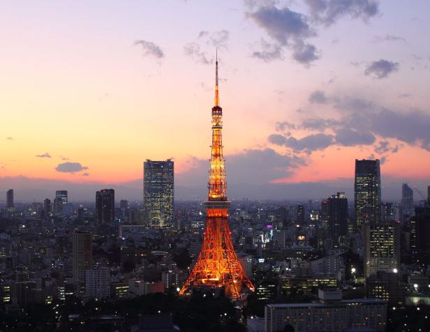 Der hell erleuchtete Tokyo Tower bei Dämmerung über der Stadt.