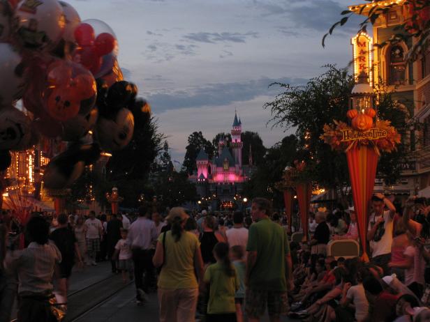 Blick auf das rosa beleuchtete Dornröschenschloss im Disneyland während der Halloween-Zeit.