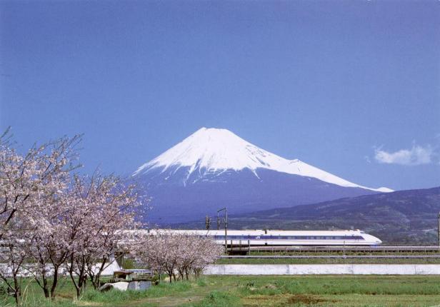 Ein Shinkansen-Hochgeschwindigkeitszug fährt vor dem schneebedeckten Berg Fuji.
