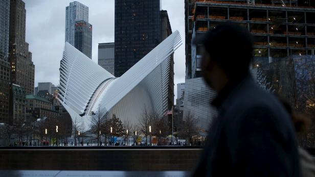 Das World Trade Center Transportation Hub in New York City mit einem unscharfen Mann im Vordergrund.
