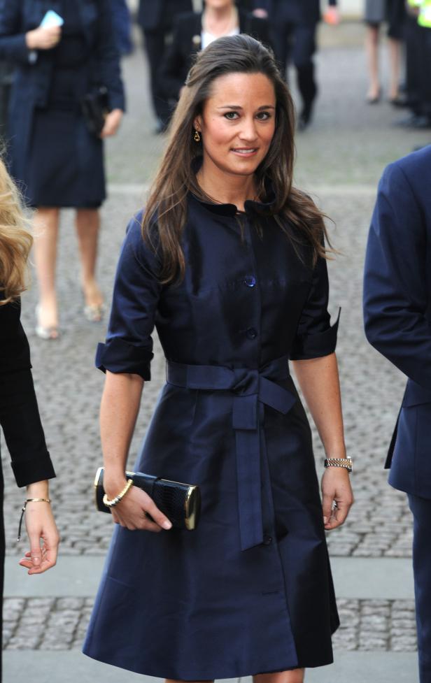 Pippa Middleton in einem eleganten, marineblauen Kleid mit Gürtel.