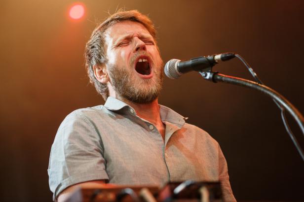Ein bärtiger Mann singt mit geschlossenen Augen in ein Mikrofon.