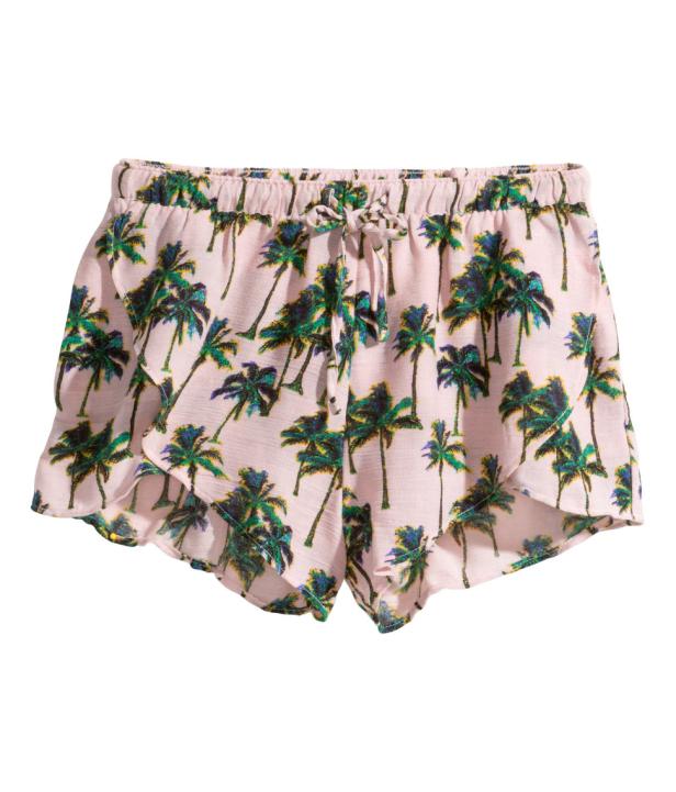 Eine kurze, rosafarbene Hose mit einem Muster aus grünen Palmen.