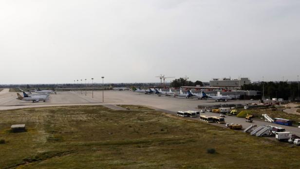 Mehrere Flugzeuge stehen auf einem Rollfeld an einem Flughafen.