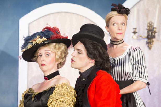 Drei Schauspieler in historischen Kostümen auf einer Theaterbühne.