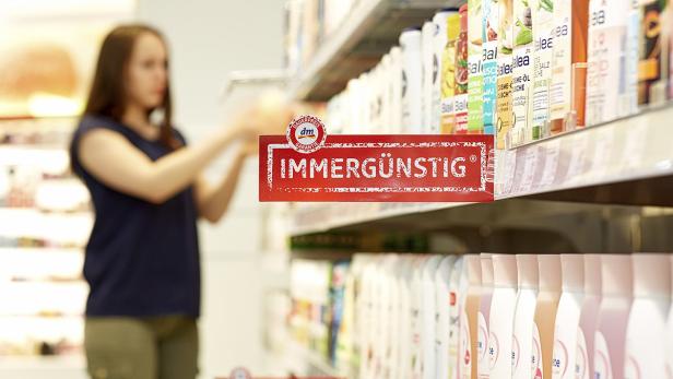 Eine Kundin im DM-Drogeriemarkt vor einem Regal mit der Aufschrift „Immergünstig“.