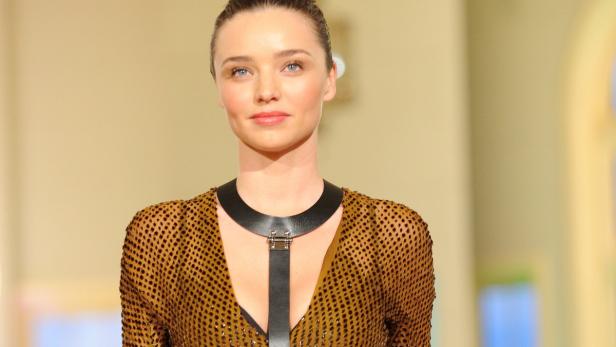 Miranda Kerr trägt ein goldenes Kleid mit einem schwarzen Lederhalsband.