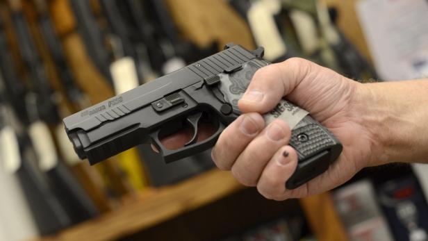 Eine Waffe aus Sig-Sauer-Produktion Eine Hand hält eine schwarze Sig Sauer P229 Pistole.