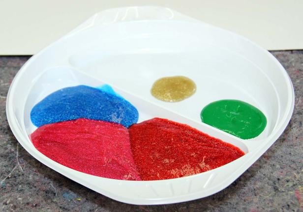 Eine weiße Schale mit blauem, rotem, goldenem und grünem Schleim.