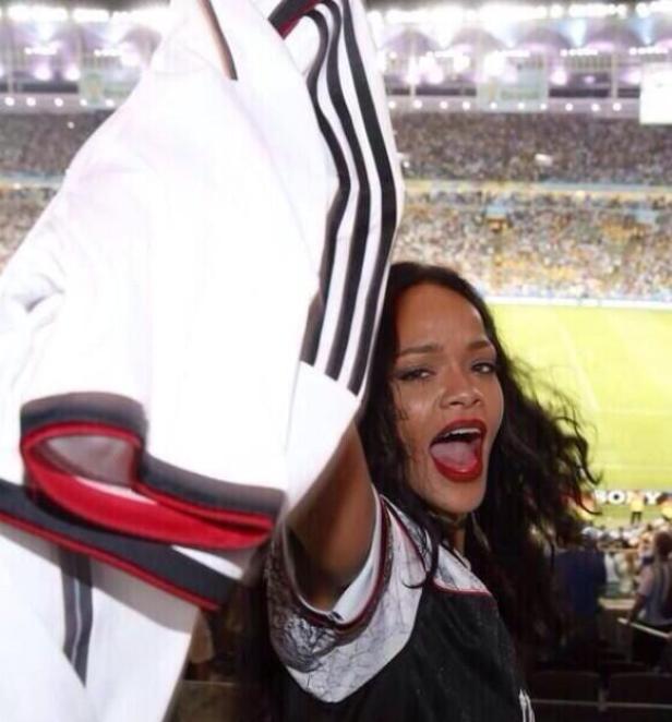 Rihanna jubelt mit einem Deutschland-Trikot auf der Tribüne eines Fußballstadions.