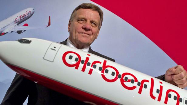 Ein Mann hält ein Modellflugzeug von Air Berlin in seinen Händen.
