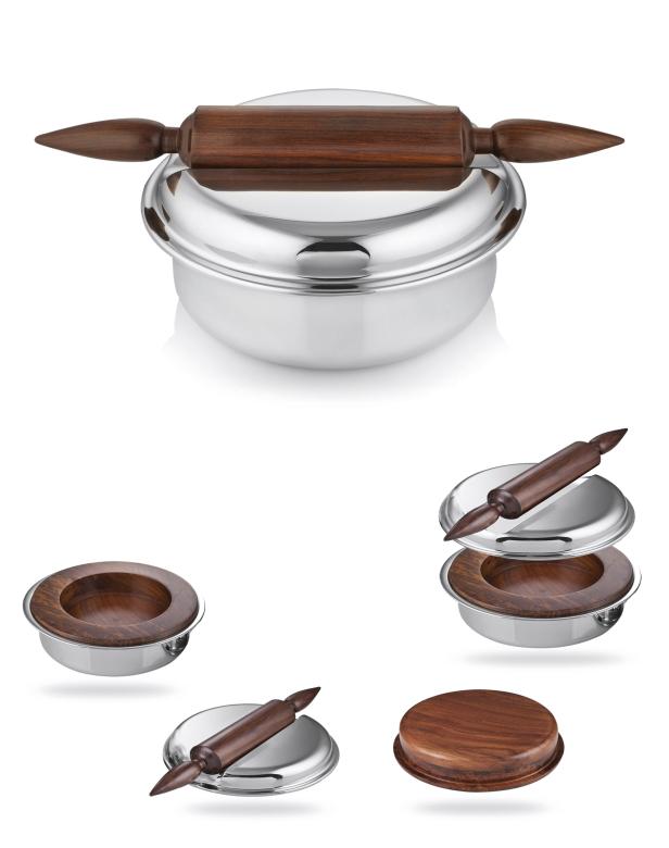 Ein Set aus einer silbernen Roti-Box mit einem hölzernen Nudelholz darauf.
